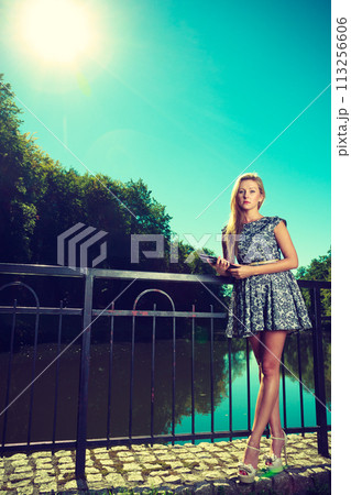 Woman sitting in park, relaxing and using tablet Woman sitting in park, relaxing and using tablet 113256606