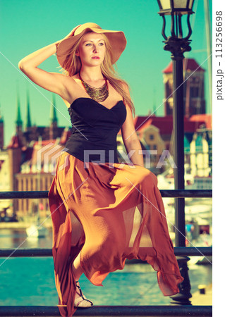Sitting woman wearing big sun hat and elegant dress Sitting woman wearing big sun hat and elegant dress 113256698
