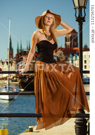 Sitting woman wearing big sun hat and elegant dress Sitting woman wearing big sun hat and elegant dress 113256701