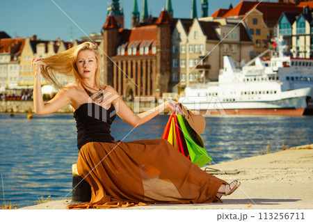 Fashionable woman resting after shopping sitting with bags 113256711