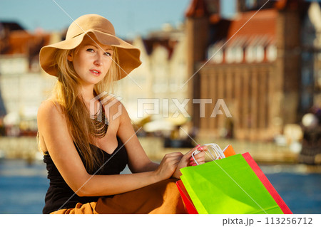 Fashionable woman resting after shopping sitting with bags 113256712