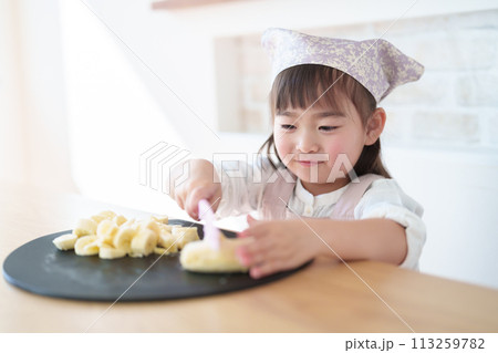 包丁でバナナをカットする女の子 113259782