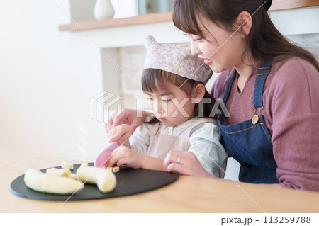 お母さんの料理を手伝う女の子 113259788