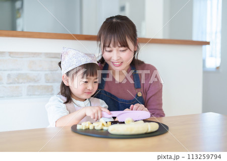 お母さんの料理を手伝う女の子 お母さんの料理を手伝う女の子 113259794