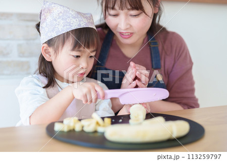 お母さんの料理を手伝う女の子 113259797