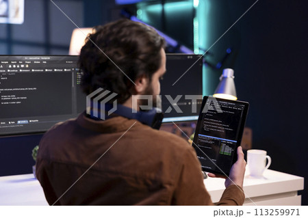 Man doing software quality assurance using tablet, reading source code before implementing it. Programmer inspecting coding on portable device, looking to fix potential bugs 113259971