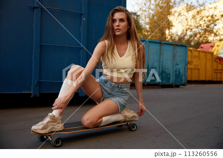 Beautiful and fashion teenage woman posing on skateboard keeping balance 113260556