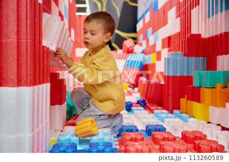 Boy child playing with huge building blocks in entertainment center Boy child playing with huge building blocks in entertainment center 113260589