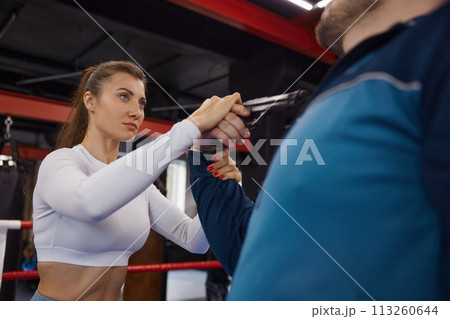 Sportive young woman training self-defense from attacker with gun weapon 113260644