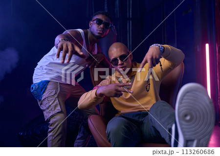 Dangerous crime boss sitting in leather armchair and his assistant 113260686