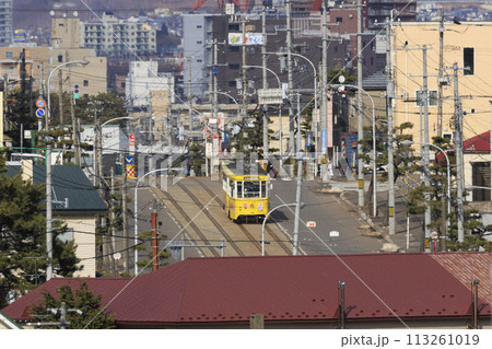 【ロゴ・ナンバー・運転手・車フロントガラスぼかし済】函館市電青柳町電停発車到着する黄色い電車 113261019