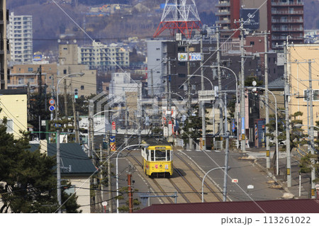 【ロゴ・ナンバー・運転手・車フロントガラスぼかし済】函館市電青柳町電停発車到着する黄色い電車 113261022