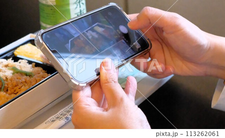 東海道新幹線で駅弁の写真をとる女性 113262061