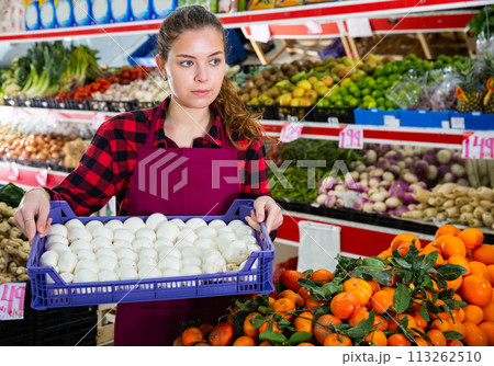 Portrait of a saleswoman holding a box of mushrooms Portrait of a saleswoman holding a box of mushrooms 113262510