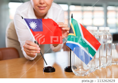 Businesswoman arranging the flags of Taiwan and South Africa for presentation and negotiations 113262629