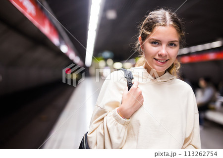 Beautiful young woman in blue jeans standing on metro station 113262754