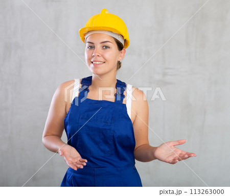 Young woman posing in work overalls in studio Young woman posing in work overalls in studio 113263000