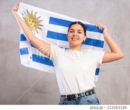 Smiling young woman holding Uruguay flag Smiling young woman holding Uruguay flag 113263184