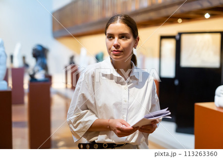 Woman looking at stone architectural elements in historical museum 113263360
