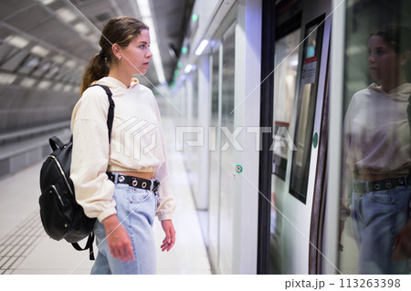 Woman entering the door of the modern train in subway 113263398