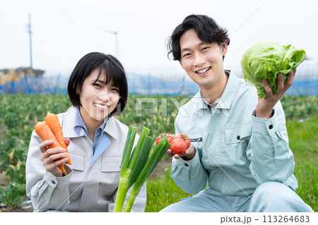 農作物を持つ農家の若い男女 113264683