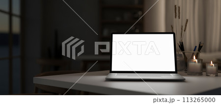 A white-screen laptop computer mockup on a table in a modern dark room. A white-screen laptop computer mockup on a table in a modern dark room. 113265000