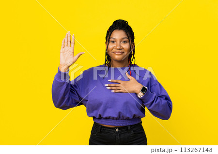 Afro Woman Pledging with Hand Over Heart on Yellow Background Afro Woman Pledging with Hand Over Heart on Yellow Background 113267148