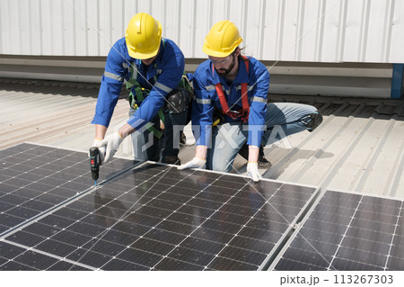 Engineers install solar cells on the roof of factory 113267303