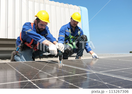 Engineers install solar cells on the roof of factory 113267306