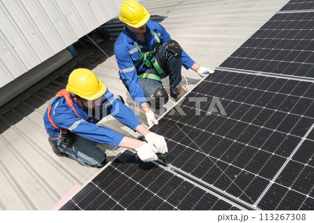 Engineers install solar cells on the roof of factory 113267308