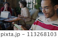 Joyful African American man playing video game with smartphone relaxing in work break in coworking office. Gaming and mobile application concept. 113268103