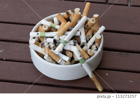 Overflowing Ashtray on Wooden Table Overflowing Ashtray on Wooden Table 113273257