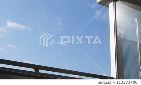 青空が見えるバルコニーと朝日を反射する窓 青空が見えるバルコニーと朝日を反射する窓 113273400