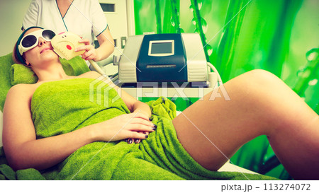 Woman getting laser treatment in beautician Woman getting laser treatment in beautician 113274072