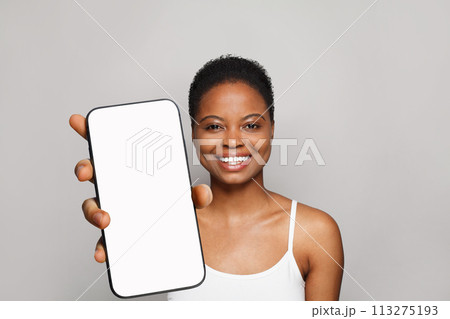 Joyful healthy woman holding smartphone with white empty blank screen display  113275193