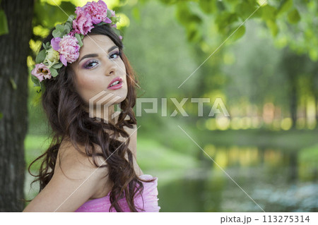 Brunette fashion model woman with healthy hair and natural makeup wearing pink dress 113275314