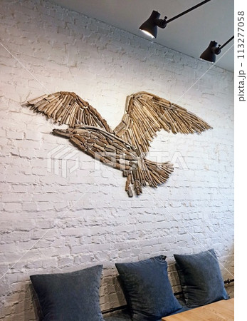 wooden bird on a white brick wall in the interior of a cafe wooden bird on a white brick wall in the interior of a cafe 113277058
