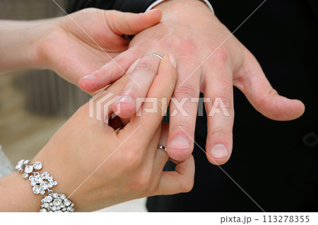 The bride puts on a ring for the groom in close-up 113278355