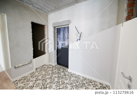 Modern apartment with doorways before and after refurbishment. Comparison of old flat and new place with white walls and modern interior design. Concept of home renovation. 113278616
