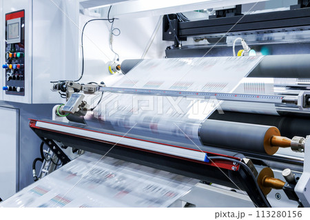 new innovative technology of automatic label printing machine with digital control panel. printing on continuous plastic film for wrapping on food product packaging in the printing factory. new innovative technology of automatic label printing machine with digital control panel. printing on continuous plastic film for wrapping on food product packaging in the printing factory. 113280156