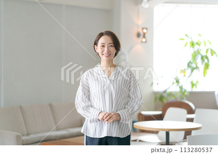 リビングルームに立つミドルの女性 リビングルームに立つミドルの女性 113280537