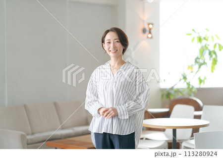 リビングルームに立つミドルの女性 リビングルームに立つミドルの女性 113280924