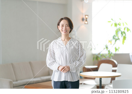リビングルームに立つミドルの女性 リビングルームに立つミドルの女性 113280925