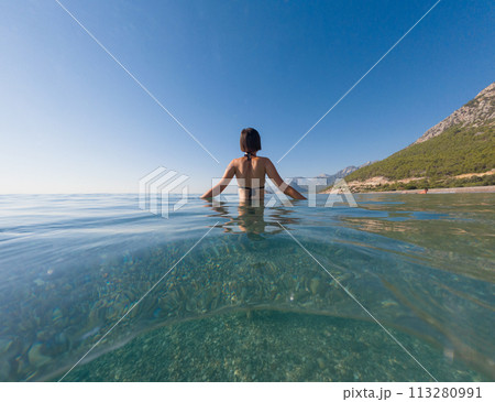 Woman on tropical vacation paradise on sea. Summer sea joy in Turkish seacoast, beaches along Lycian Way, Turkish Riviera. Asian female underwater and turquoise ocean around. 113280991