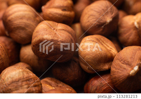 Close-up of Hulled whole cobalt or hazelnut seeds of Corylus avellana. Macro photo of food, close up from above Close-up of Hulled whole cobalt or hazelnut seeds of Corylus avellana. Macro photo of food, close up from above 113281213