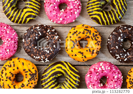 Set of colorful donuts on wooden background Set of colorful donuts on wooden background 113282770