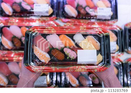 パック入りのお寿司を持った子供の手 113283769