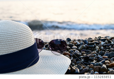 Sunglasses and hat on the beach. the concept of travel. Sunglasses and hat on the beach. the concept of travel. 113283851