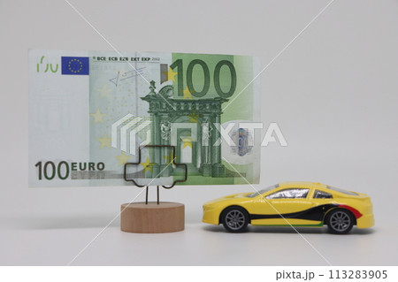 A toy car stands next to a banknote on a stand. Accurate financial calculation when buying a car. A toy car stands next to a banknote on a stand. Accurate financial calculation when buying a car. 113283905
