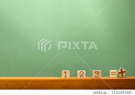数字ブロックと計算の記号のブロックが置かれた緑の黒板風の背景 113285560